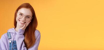 Smiling satisfied happy redhead girl get rid acne delighted touching soft clean skin laughing joyfully talking feel confidence self-assured own beauty, standing orange background enjoy communication photo