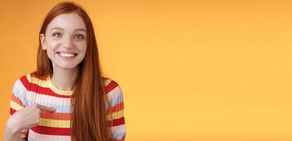 Happy excited grinning redhead girl chosen smiling gratitude delighted gladly pointing herself look surprise thankful camera got job, receive scholarship standing orange background photo