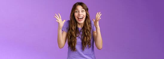 Cheerful surprised happy girl receive unbelievable super prize winning triumphing smiling joyfully shake hands excitement joy celebrating perfect news grinning happily victory purple background photo