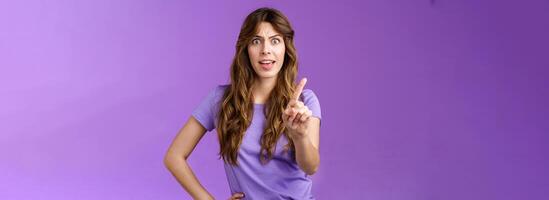 Displeased offended serious-looking assertive woman forbid express dislike and disapproval frowning annoyed shaking index finger prohibit refusing offensive behaviour stand purple background photo