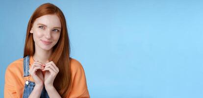 Devious tricky young girl have excellent plan smirking delighted mysteriously look upper left corner smiling have idea thoughtfully twiddles fingers standing rejoicing blue background photo