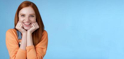 Enthusiastic sassy good-looking redhead caucasian girl lean head palms look amused intrigued listen interesting story pleased smiling laughing silly jokes standing blue background excited happy photo