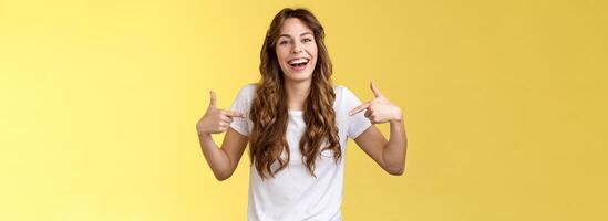 Haha awesome. Positive sincere attractive young woman curly long hair laughing joyfully pointing fingers center copy space white t-shirt chuckling having fun discuss great link show you promo photo