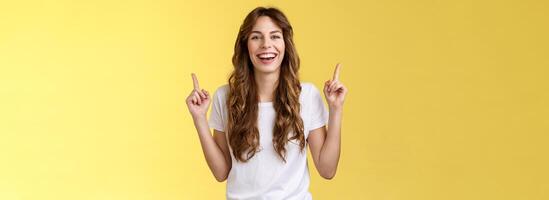 carismático entusiasta atractivo animado mujer teniendo divertido disfrutar increíble noche fuera fiesta riendo alegremente señalando arriba índice dedos arriba introducir promoción sonriente felizmente amarillo antecedentes foto