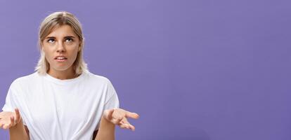 no yo tener No idea. retrato de irritado molesto guapo europeo mujer con justa pelo laminación ojos arriba con decepcionado expresión encogiéndose de hombros con manos elevado en despistado gesto foto