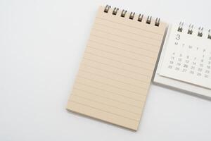 Empty Spiral notepad with brown lined papers and Simple desk calendar for MARCH in isolated background. Memo concept with copy space. photo