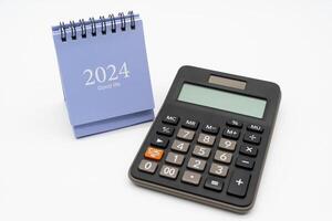 Financial, plan for money saving. Calculator and 2024 desk calendar isolated on white background. Goals, Plan, Action, Money Saving, Retirement fund, Pension, Investment and Financial concept. photo