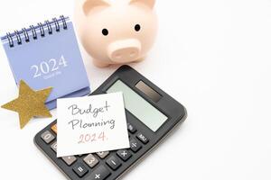 Budget Planning 2024 text message by hand writing on paper note, Calendar 2024, Golden Star, Calculator and Piggy bank. Budget planning concept. photo