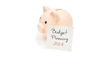 Budget Planning 2024 text message by hand writing on paper note and Piggy bank. Budget planning concept. photo