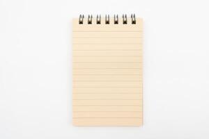 Spiral notepad in isolated background. Blank one face brown paper note. empty sheet of brown lined papers. photo