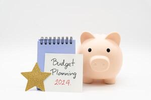 Budget Planning 2024 text message by hand writing on paper note, Calendar, Golden Star and Piggy bank. Budget planning concept. photo