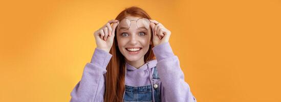 Impressed excited happy pleased young silly lovely redhead girl receive pleasing surprise take off glasses wide eyes touched smiling delighted gasping amazed feel upbeat thrilled photo