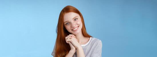 Romantic tender lovely redhead girlfriend tilting head press palms together smiling touched look sympathy check out cute picture friend standing delighted amused, heartwarming moment photo