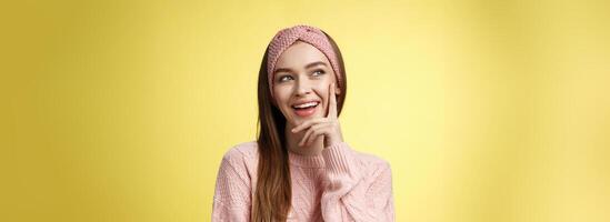 Girl having great idea, smirking delighted, proud herself, touching cheek smiling amused creating plan in mind looking at upper left corner pleased, intrigued and excited seeing awesome opportunity photo