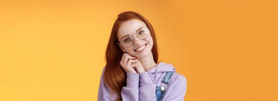 Tender feminine ginger girl blue eyes wearing glasses hoodie lean palms smiling receive sweet cute gift think you lovely grateful dearest friend grinning joyful spread love, orange background photo