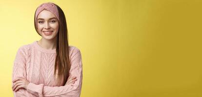 Waist-up shot of confident creative joyful cute european female model in knitted pink sweater, headband, cross arms self-assured, satisfied, smiling pleased and motivated, looking delighted photo