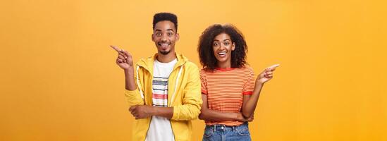 cuales uno narración verdadero. alegre y simpático guapo pareja, africano americano mujer señalando izquierda y de piel oscura chico Derecha sonriente en general a cámara dando consejos pero discrepar con cada otro foto