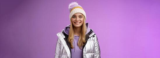 Amused fascinated attractive excited blond woman stepping skis first time feel temptation thrill joyfully smiling widen eyes impressed cannot wait learn snowboarding standing silver jacket photo