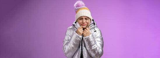 infeliz sollozando gimoteo linda rubio niña Halar chaqueta apretado cuerpo cerca ojos llorando congelación frío en pie Nevado invierno recurso sacudida bajo temperatura, púrpura antecedentes sufrimiento incomodidad foto