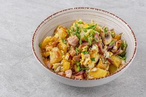 fried potatoes with mushrooms and ham on a stone background studio food photo 2