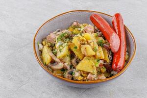 fried potatoes with mushrooms and sausages on a stone background studio food photo 4