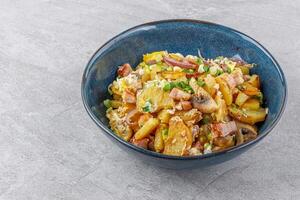 fried potatoes with mushrooms and ham on a stone background studio food photo 1