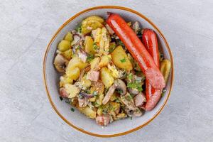 fried potatoes with mushrooms and sausages on a stone background studio food photo 2