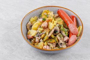 fried potatoes with mushrooms and sausages on a stone background studio food photo 3