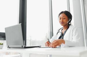 Telehealth, African American doctor in headset consulting with the patient over the phone call. Health care call center and telehealth online concept. photo