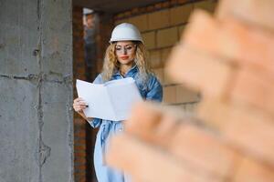 almacén mujer obrero. mujer constructor en casco de seguridad. niña ingeniero o arquitecto. hogar renovación. calidad inspector. construcción trabajo ocupación. construcción obrero. dama a construcción sitio. foto