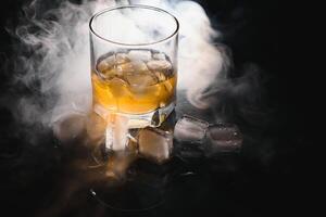 Glass of scotch whiskey and ice photo