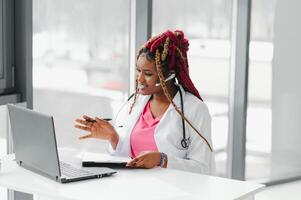 Pretty young smart female doctor or therapist giving health care advice online by webcam videochat and consulting distant patient. Remote medical services. Telemedicine photo