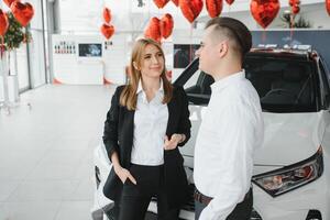 Family selfie in dealership. Happy young couple chooses and buying a new car for the family photo