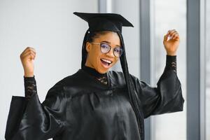 contento africano americano hembra estudiante con diploma a graduación foto