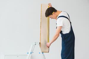 trabajador con materiales para instalando laminado piso foto