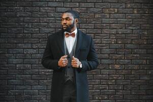 Fashion portrait of a handsome young African American business man walking outdoors in a casual pose. photo