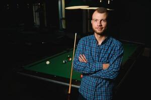 portrait of a young man playing billiards photo