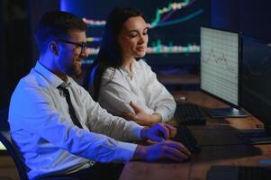 Team of traders working at monitor computer and browsing online in trading office photo