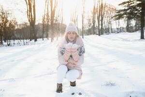 Beautiful winter portrait of young woman in the winter snowy scenery photo