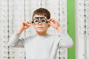 Boy with trial frame. Kid patient to check vision in ophthalmological clinic photo