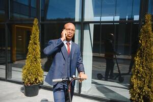 Young African businessman Riding An Electric Scooter photo