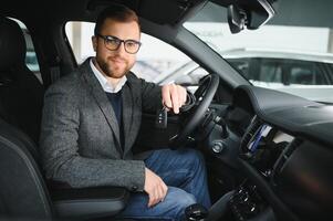 visitando coche concesión. hermoso barbado hombre es acariciando su nuevo coche y sonriente foto