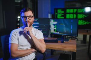 Male programmer working on desktop computer at white desk in office photo