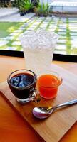 Espresso shot with orange juice, ice soda and spoon on wooden tray with above copy space. Refreshment, Drinking water and Cafe concept. photo