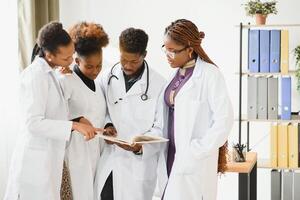 Doctors having a conversation looking at documents, mixed races, surgeons and doctors. photo