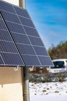 Solar panels with snow on ground on a well-exposed wall of an individual house, making savings following the energy crisis, eco-citizen gesture, green energy photo