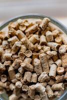 Pellet for stove or boiler in a glass, compressed wood granule photo