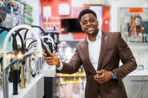 Portrait of buyer in bathroom store. Man is choosing faucet for his apartment. photo