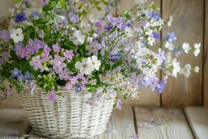 AI generated Bouquet of delicate spring flowers in a white wicker basket. Generative AI photo