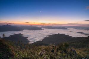 mountain with foggy on ground at morning time photo